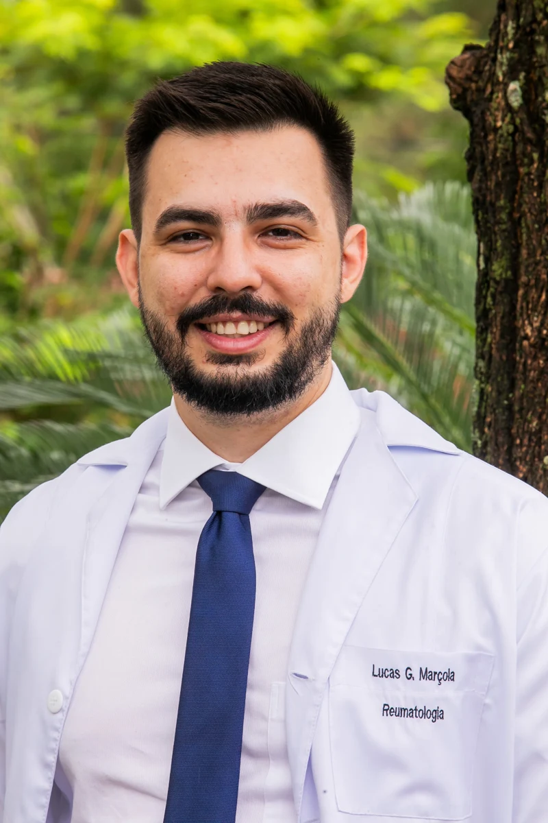 Dr. Lucas Marçola com jaleco de reumatologia